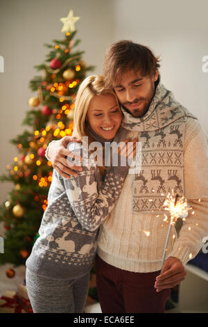 Happy young guy and girl celebrating xmas or New Year together Stock Photo