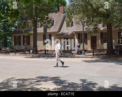 A costumed interpreter passes Chowning's Tavern in Colonial Williamsburg, Virginia Stock Photo