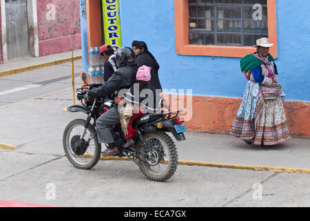 Street scene in Peru. Motorcyclist and pedestrians. Modern and traditional dress. Stock Photo