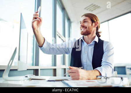 Male employee making selfie at workplace in office Stock Photo