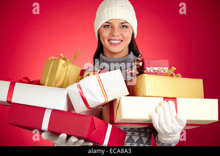 Portrait of smiling female holding stack of giftboxes Stock Photo