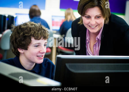 Teacher helping student with work on computer Stock Photo