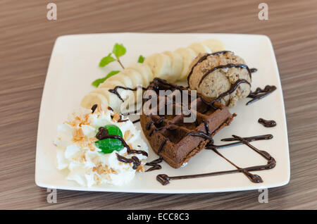 ice cream , banana , chocolate waffles with chocolate sauce and whipping cream Stock Photo