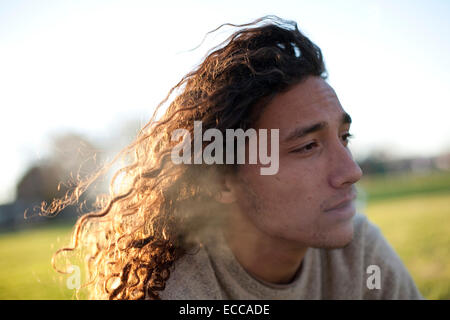 Portrait of young man with longer curly hair. Stock Photo