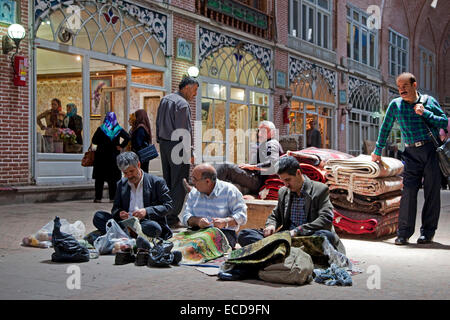 Iranian men repairing carpets in the old historic bazaar of the city Tabriz, East Azerbaijan, Iran Stock Photo