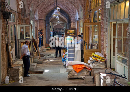 Iranian vendors selling antiques and fabrics in shops in the old historic bazaar of the city Tabriz, East Azerbaijan, Iran Stock Photo