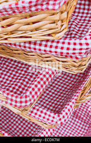 Pile of straw baskets lined by gingham cloths Stock Photo