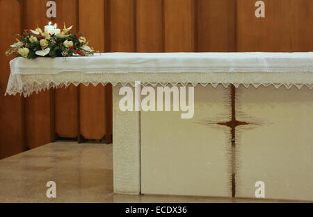 beautiful bouquet of flowers with two lit candles on the altar of the Church Stock Photo