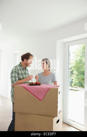 Happy couple new house celebrating drinking Stock Photo