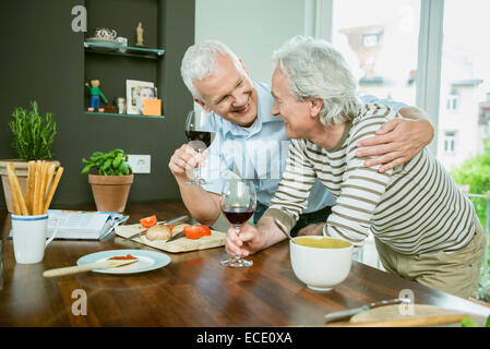 Friends chatting and drinking wine, smiling Stock Photo