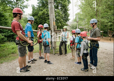 Young woman giving instruction to group of people for climbing crag Stock Photo
