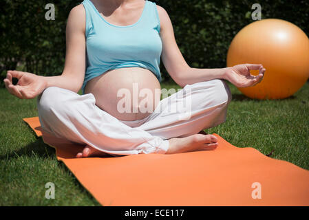 Close-up meditating pregnant woman garden Stock Photo