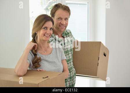 Couple working carrying boxes new home Stock Photo