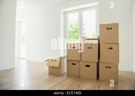Cardboard boxes pile stack new home empty room Stock Photo