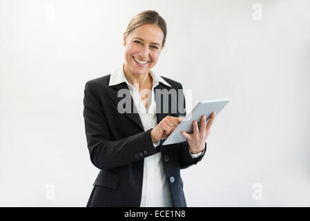 Portrait of businesswoman in black suit using digital tablet, smiling Stock Photo