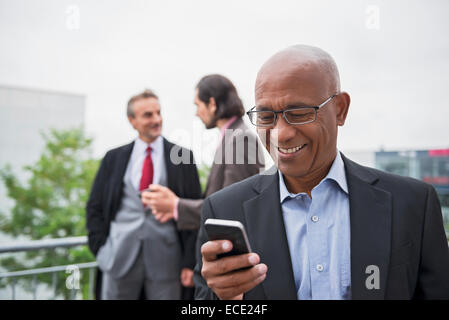 Three businessmen African Smartphone SMS realtor Stock Photo