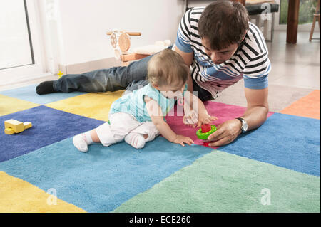 Playing toy father baby girl daughter carpet Stock Photo