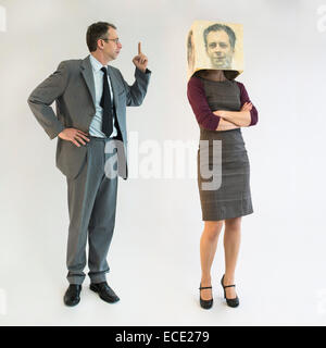 businessman scolding businesswoman wearing mask Stock Photo