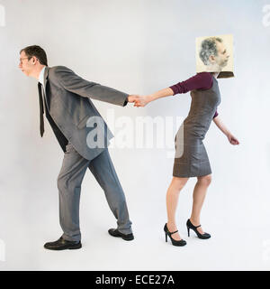 businessman pulling businesswoman wearing mask Stock Photo