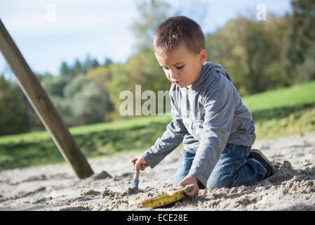 Portrait boy playing shovel sieve sand playground Stock Photo