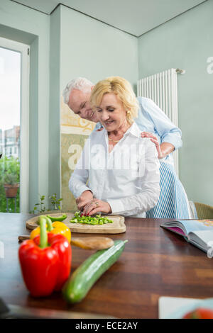 Senior couple kitchen preparing dinner loving Stock Photo