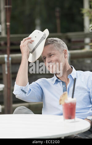 Man sitting table straw hat cocktail relaxing Stock Photo