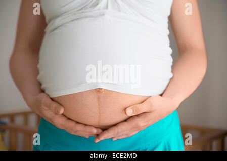 Woman pregnant stomach close-up holding Stock Photo