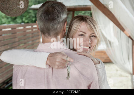 Loving couple hugging garden woman holding keys Stock Photo