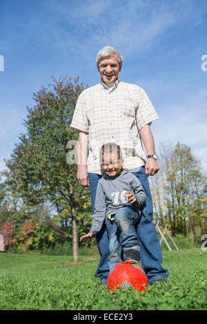 Grandfather and grandson playing football Stock Photo
