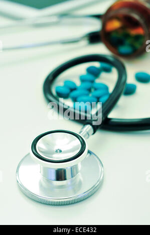 closeup of the desk of a doctors office with a stethoscope and a bottle with pills Stock Photo