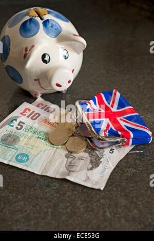 Close up of Piggy bank and English British cash money banknotes concept England UK United Kingdom GB Great Britain Stock Photo
