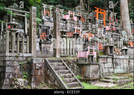 Kyoto, Japan. A Shinto graveyard on the mountainside at the shrine of Fushimi Inari-taisha, with many small torii gates Stock Photo