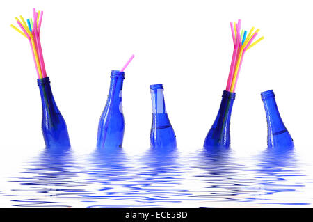 Blue bottles with coloured straws floating in water Stock Photo