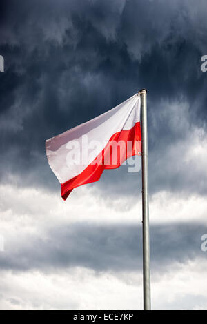 Poland flag on a dark cloudy dramatic sky. Stock Photo