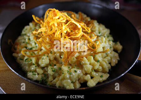 Kaesespaetzle (cheese dumplings) served with deep fried onions in Lech, Austria. Stock Photo