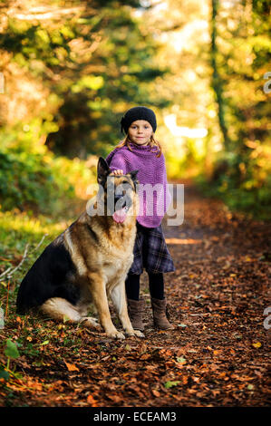 Young girl (2-3) with german shepherd in park Stock Photo