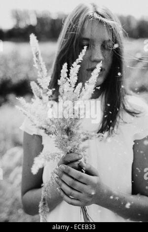 Russia, Teenage girl (14-15) with bouquet of grass Stock Photo
