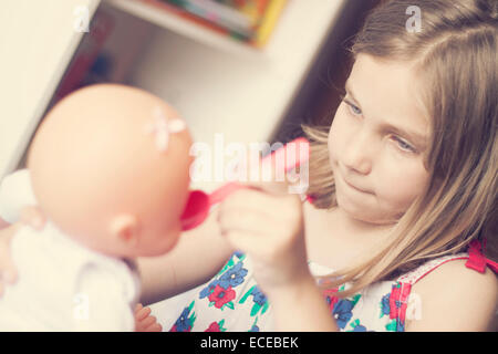 Girl  playing with a doll Stock Photo