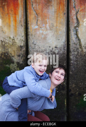 Mother giving son piggyback ride Stock Photo