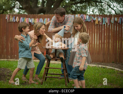 Family celebrating baby boys' first birthday in back yard Stock Photo