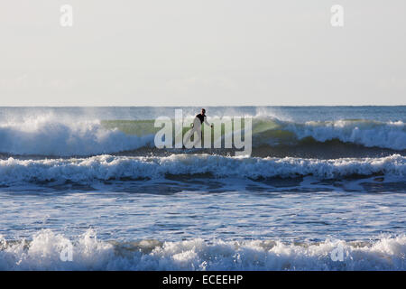 Surfer riding the waves at Saunton UK. The bay in North Devon is popular with surfers and boarders Stock Photo