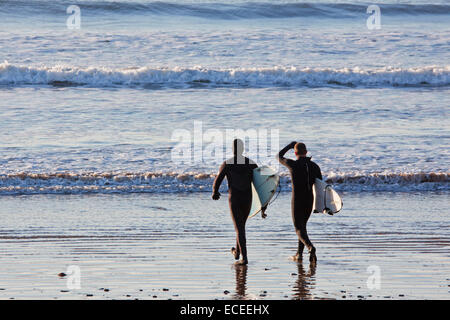 Two surfers on Saunton sands UK prior to entering the water to begin a session riding the waves Stock Photo