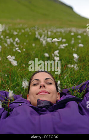 Young woman relaxing in the mountain fields of Kalsoy, Faroe Islands Stock Photo