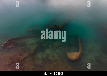 Sunken fishing boats below water, abandoned in the small port of Zea Marina in Greece Stock Photo