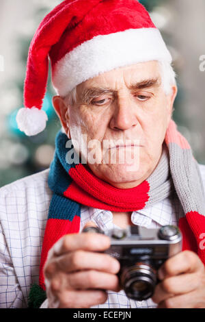 Senior man taking photo against Christmas background Stock Photo