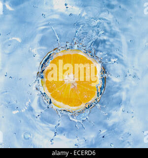 Fresh lemon dropped into water with bubbles isolated on white Stock Photo