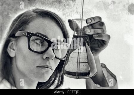 Researcher holding a glass beaker in a lab Stock Photo