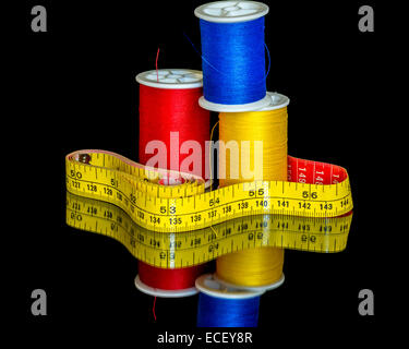 Stacked spools of thread and a measuring tape Stock Photo