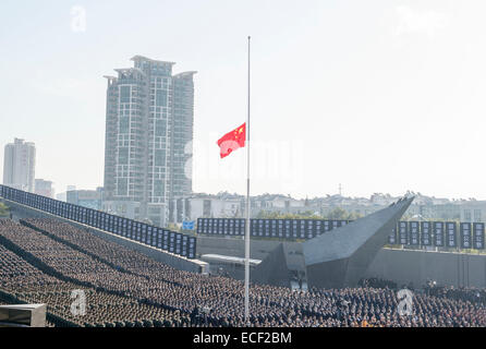 Nanjing, China's Jiangsu Province. 13th Dec, 2014. The Chinese national flag flies at half-mast at the state ceremony for China's first National Memorial Day for Nanjing Massacre Victims at the memorial hall for the massacre victims in Nanjing, east China's Jiangsu Province, Dec. 13, 2014. Credit:  Xinhua/Alamy Live News Stock Photo