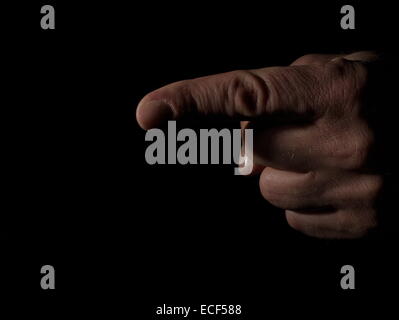 Man's hand pointing on black background Stock Photo